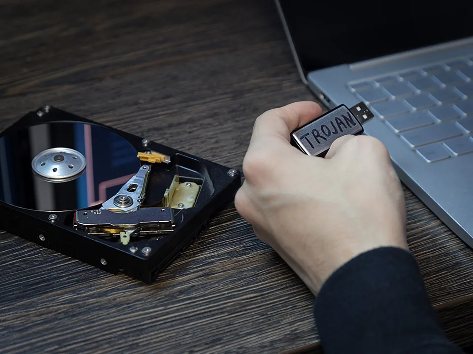 A floppy drive and a man injecting trojan virus